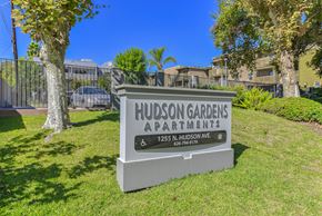 Pasadena apartment for rent - A sign for Hudson Gardens Apartments stands in a grassy area.
