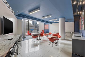 Brooklyn apartment for rent - A modern dining area with red chairs and a wooden table.
