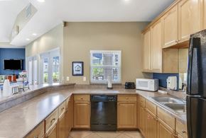 Orlando apartment for rent - A kitchen with wooden cabinets and a black refrigerator.