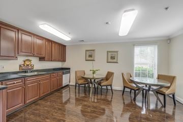 Germantown apartment for rent - A kitchen with brown cabinets and a dining table with chairs.