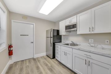 Largo apartment for rent - A kitchen with white cabinets and a black fridge.