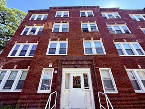 Roxbury apartment for rent - A red brick building with a white door and windows.