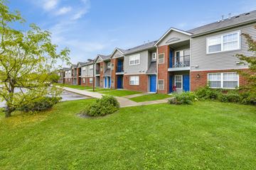 Detroit apartment for rent - A row of townhouses with green lawns in front.