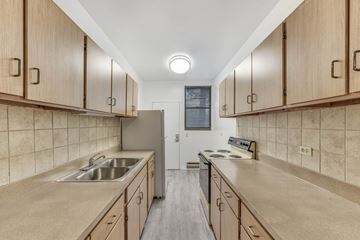 Chicago apartment for rent - A kitchen with wooden cabinets and a tiled backsplash.