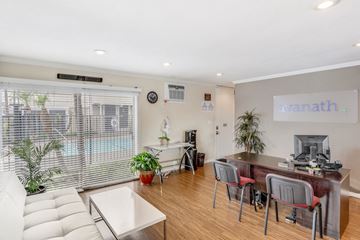Long Beach apartment for rent - A living room with a white couch and a desk with a computer on it.