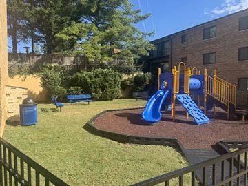 Alexandria apartment for rent - A playground with a blue slide and yellow fence.