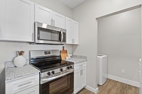 Foley apartment for rent - A kitchen with white cabinets and a stove top oven.