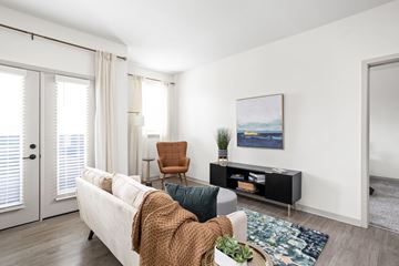 Indianapolis apartment for rent - A living room with a white couch, a brown chair, and a painting on the wall.