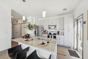 Windsor apartment for rent - A modern kitchen with a granite countertop and black chairs.