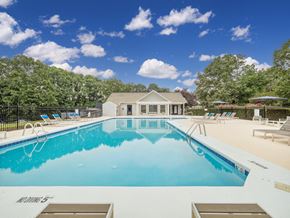 Raleigh apartment for rent - a pool with lounge chairs and a house in the background