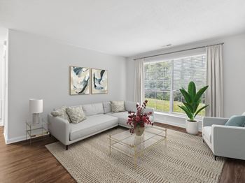 A living room with a white couch and a large window