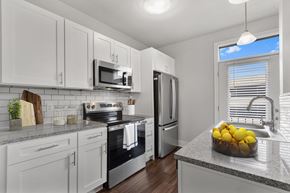 Indianapolis apartment for rent - A kitchen with white cabinets and a granite countertop at CityWay Apartments, Indiana 46204