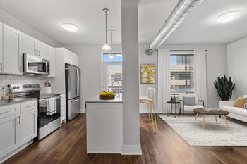 A modern kitchen with white cabinets and stainless steel appliances.