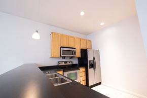 Indianapolis apartment for rent - a kitchen with a black counter top and stainless steel appliances at 26 West, Managed by Buckingham Urban Living, Indianapolis