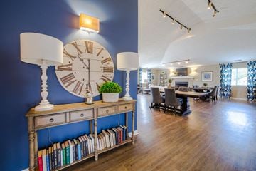 Terre Haute apartment for rent - a living room with a large clock on the wall and a table with chairs