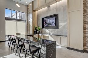 Carmel apartment for rent - a kitchen with a bar with chairs and a tv on the wall