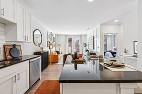 Cincinnati apartment for rent - A modern kitchen with a black countertop and white cabinets.