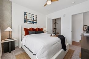 Cincinnati apartment for rent - Bedroom at Contrast OTR in Cincinnati, OH with mid-century modern decor, wood nightstand, and bright window views.