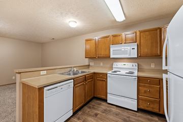 Terre Haute apartment for rent - A kitchen with white appliances and wooden cabinets.