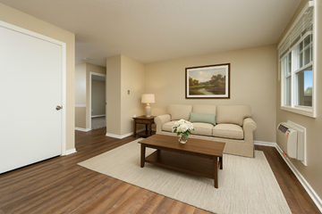 Huntington apartment for rent - A living room with a brown coffee table and a painting on the wall.