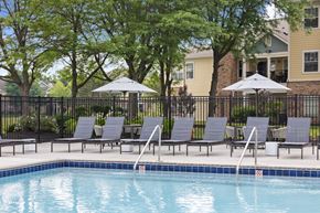 Indianapolis apartment for rent - Shaded poolside seating area with loungers and umbrellas at Center Point Apartments offering a peaceful spot to relax outdoors.