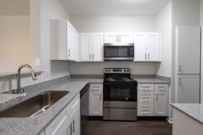 Indianapolis apartment for rent - Renovated kitchen featuring black appliances and granite counters at Center Point Apartments, Indianapolis