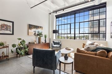 Indianapolis apartment for rent - A living room with a brown couch, a black chair, and a table with a vase on it.