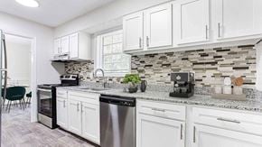Marietta townhouse for rent - an open kitchen with white cabinets and a counter top at Elea Apartments in Marietta, GA