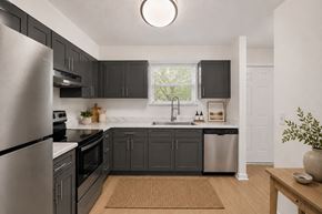 Nashville apartment for rent - A modern kitchen with dark grey cabinets and stainless steel appliances.