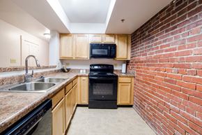 Indianapolis apartment for rent - Modular Kitchen with Black Appliances wide view at Lockerbie Court on Mass Ave, Indianapolis, Indiana