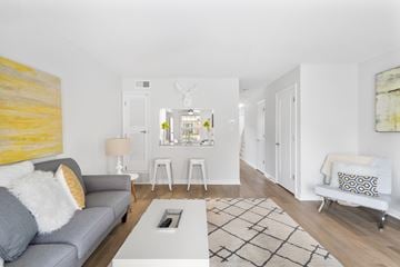 Indianapolis apartment for rent - A living room with a grey couch and a yellow painting on the wall.
