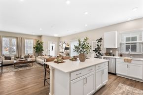 Lewis Center apartment for rent - Modern kitchen in single-family rental home at Mural Lewis Center featuring large island with seating, white cabinetry, stainless steel appliances, quartz countertops, and open-concept design