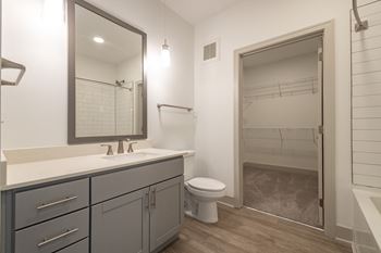 A bathroom with a shower and a sink and a mirror