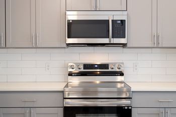 A white kitchen with a stove and a microwave