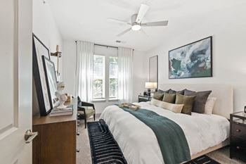 A bedroom with a bed and a ceiling fan