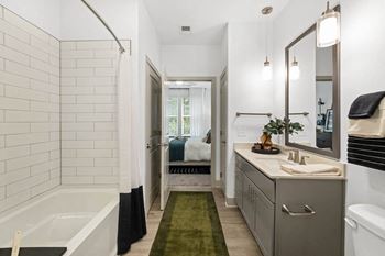 A bathroom with a tub and a sink and a mirror