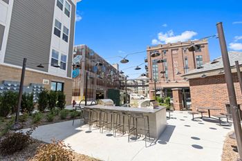 A patio with a bar and chairs in front of a building