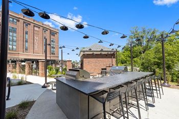 A long bar with chairs and a building in the background