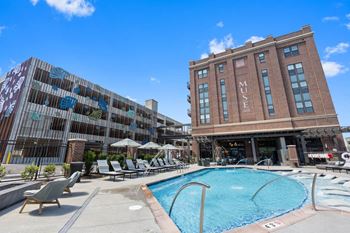 A swimming pool at a hotel with a building in the background
