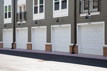 A row of white garage doors on a house
