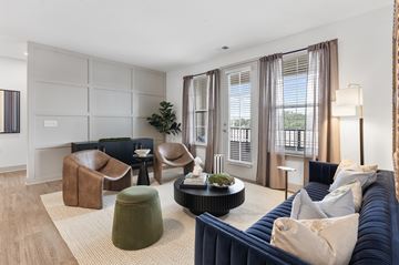 Carmel apartment for rent - A living room with a blue couch and a green ottoman.
