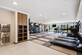 Carmel apartment for rent - Modern apartment gym fully equipped with cardio machines, weight training equipment, a flat-screen TV, individual storage cubbies, and a convenient resident hydration station.
