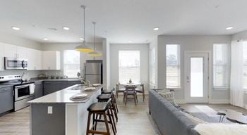 A modern kitchen with a large island and a dining area.