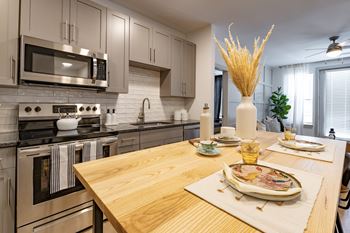 A kitchen with stainless steel appliances and a wooden table