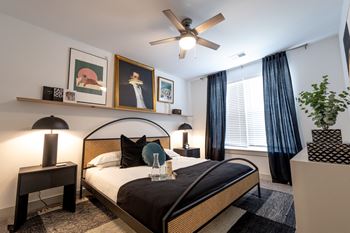 A bedroom with a large bed and a ceiling fan