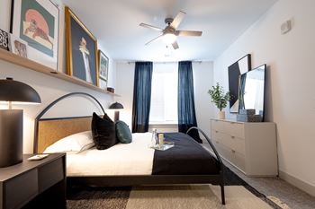 A bedroom with a bed and a ceiling fan