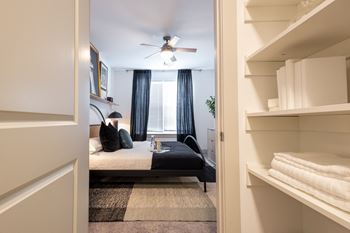A bedroom with a bed and a ceiling fan