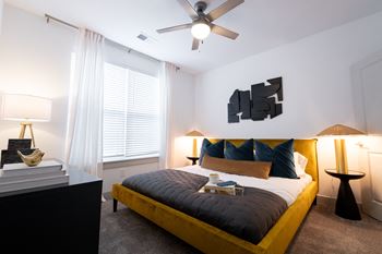 A bedroom with a large bed and a ceiling fan