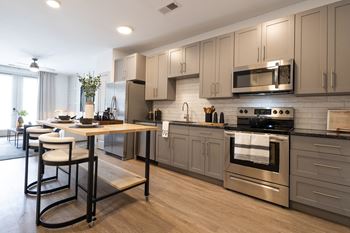 A kitchen with gray cabinets and stainless steel appliances