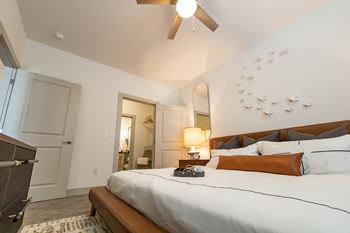 A bedroom with a large bed and a ceiling fan